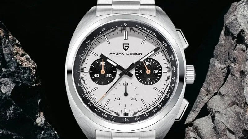 Sterling Chrono watch on dark rock, white panda dial with three chronograph sub-dials, crown and both pushers visible