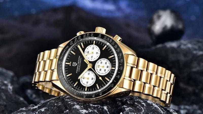 Pagani Design Gold Summit gold chronograph with a black dial, resting on dark rock