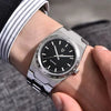 Royal Slim dress watch on a wrist, emerging from a striped shirt cuff under a suit