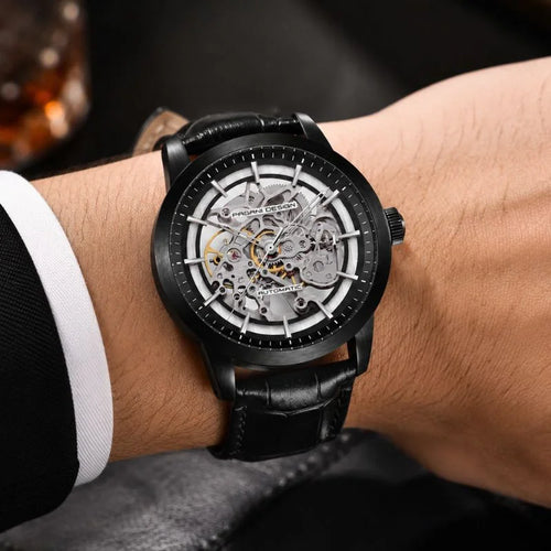 Man wearing the all-black Artisan Open Dial by Pagani Design against a warm dark background