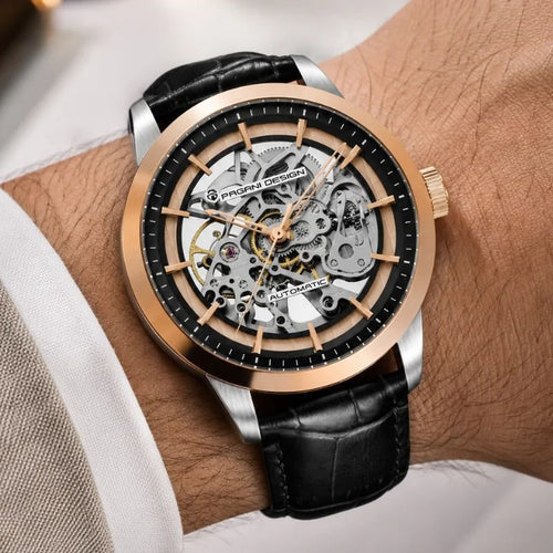 En la muñeca, el Artisan Open Dial en oro rosa y negro de Pagani Design con correa de piel negra