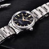 Black-dial Aurum Frost by Pagani Design beside a fountain pen on dark leather