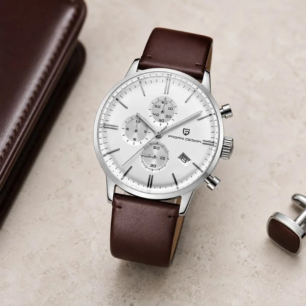 Steel Royal Chrono by Pagani Design on a cream surface with a leather wallet and cufflink