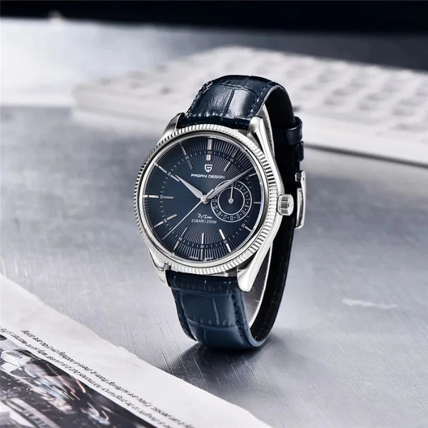 Blue-dial Vanguard Classic by Pagani Design on a desk beside a keyboard and newspaper