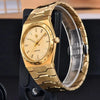 Gold Royal Slim Sapphire by Pagani Design angled with the bracelet open on a wooden backdrop